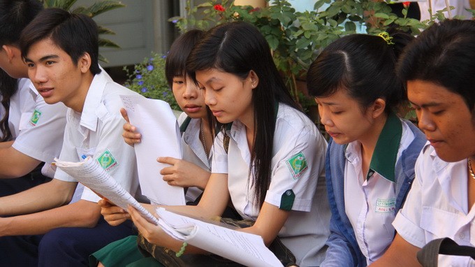 Thí sinh ở TP.HCM tranh thủ xem bài trước khi bước vào phòng thi tốt nghiệp THPT năm 2012 - Ảnh: H.Hương