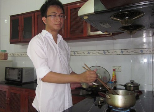 Thủ khoa Nguyễn Thành Trung chuẩn bị nấu cơm trưa cho gia đình. Ảnh: Hải Bình.
