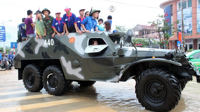 Xe thiết giáp của Bộ chỉ huy quân sự tỉnh Thái Nguyên đưa thí sinh và người nhà qua khu vực ngập nước để đi thi - Ảnh: Thiều Chung